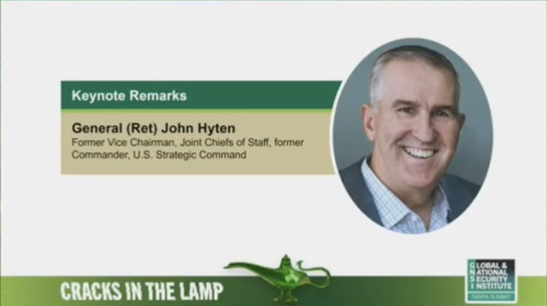 A presentation slide featuring a photo of General (Ret) John Hyten, who is smiling and wearing a suit and blue checked shirt. The slide includes text highlighting his role as a keynote speaker, his former positions, and the event's theme, "Cracks in the Lamp," with a logo of the Global & National Security Institute at the bottom right corner.