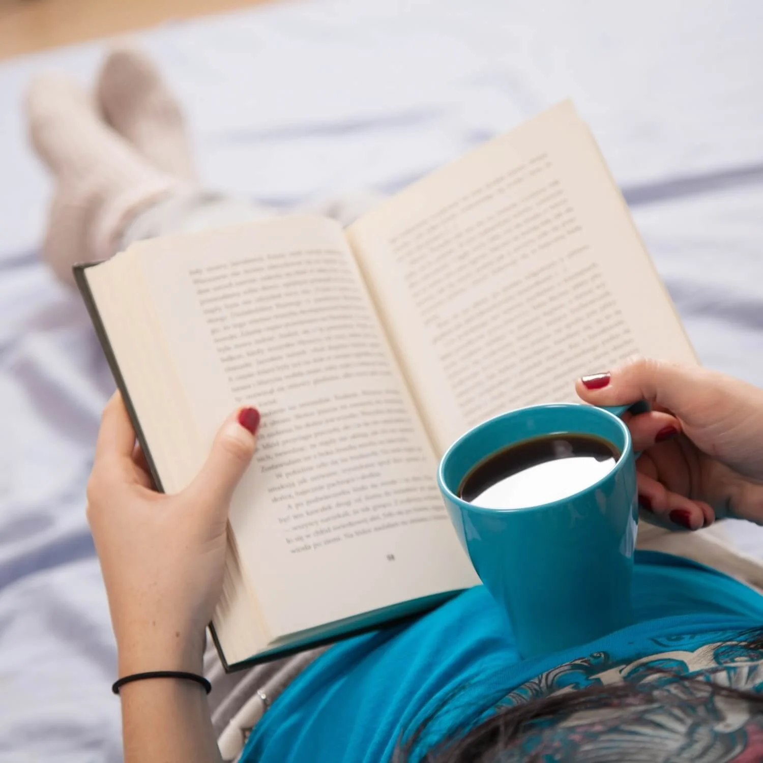 Woman ready cozy mystery fiction with coffee.
