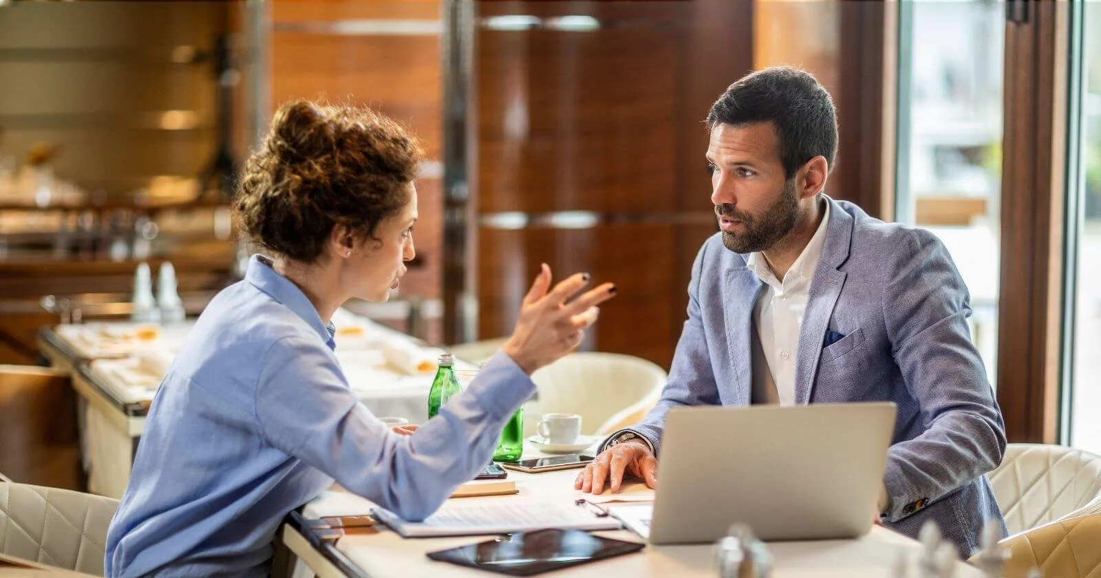 Business man and woman discussing channel partner recruitment over coffee.