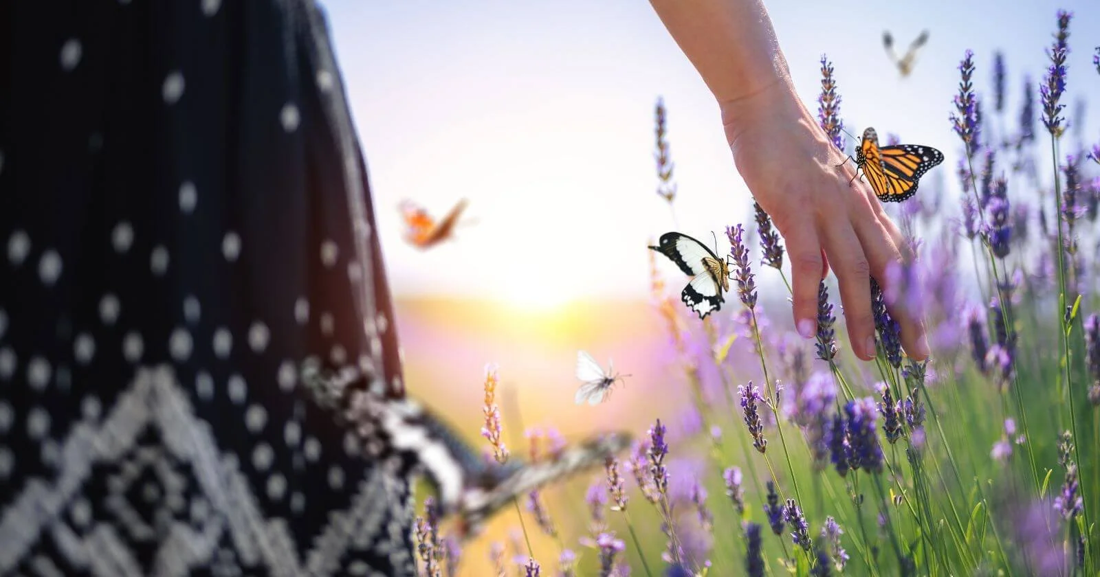 Woman practicing stress reduction and mindfulness walking through lavender fields.