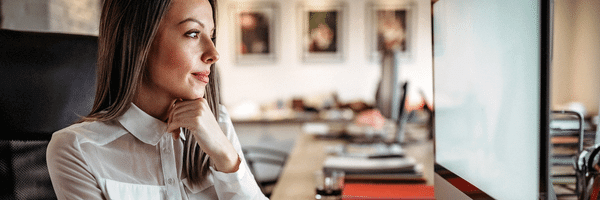 Lady at office computer contemplates women superpowers in business.