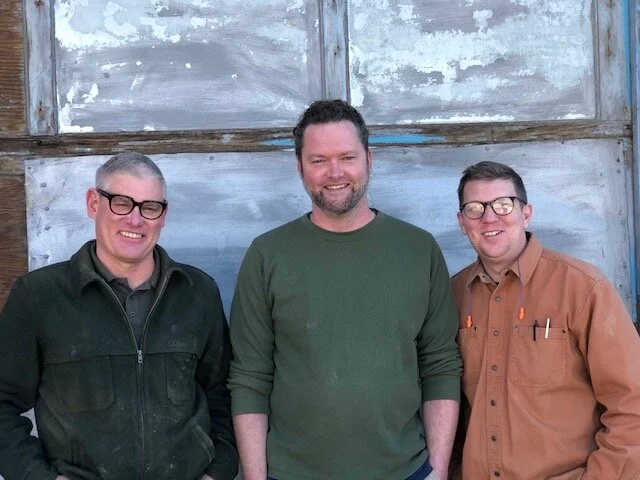 Master craftsman Ethan Hutchinson and team in custom wood workshop.