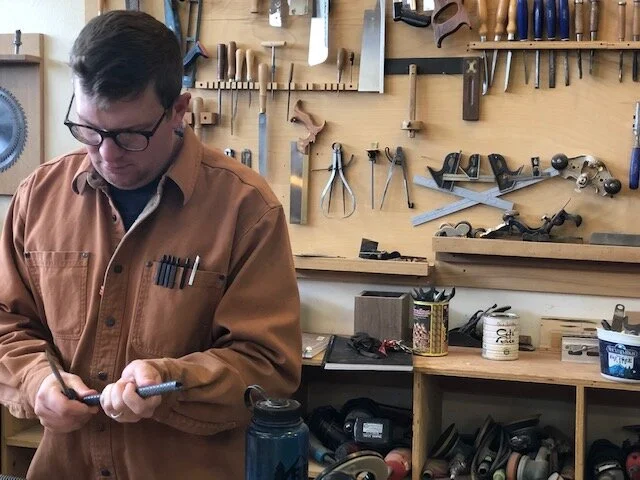 Woodworker using traditional tools in wood workshop class
