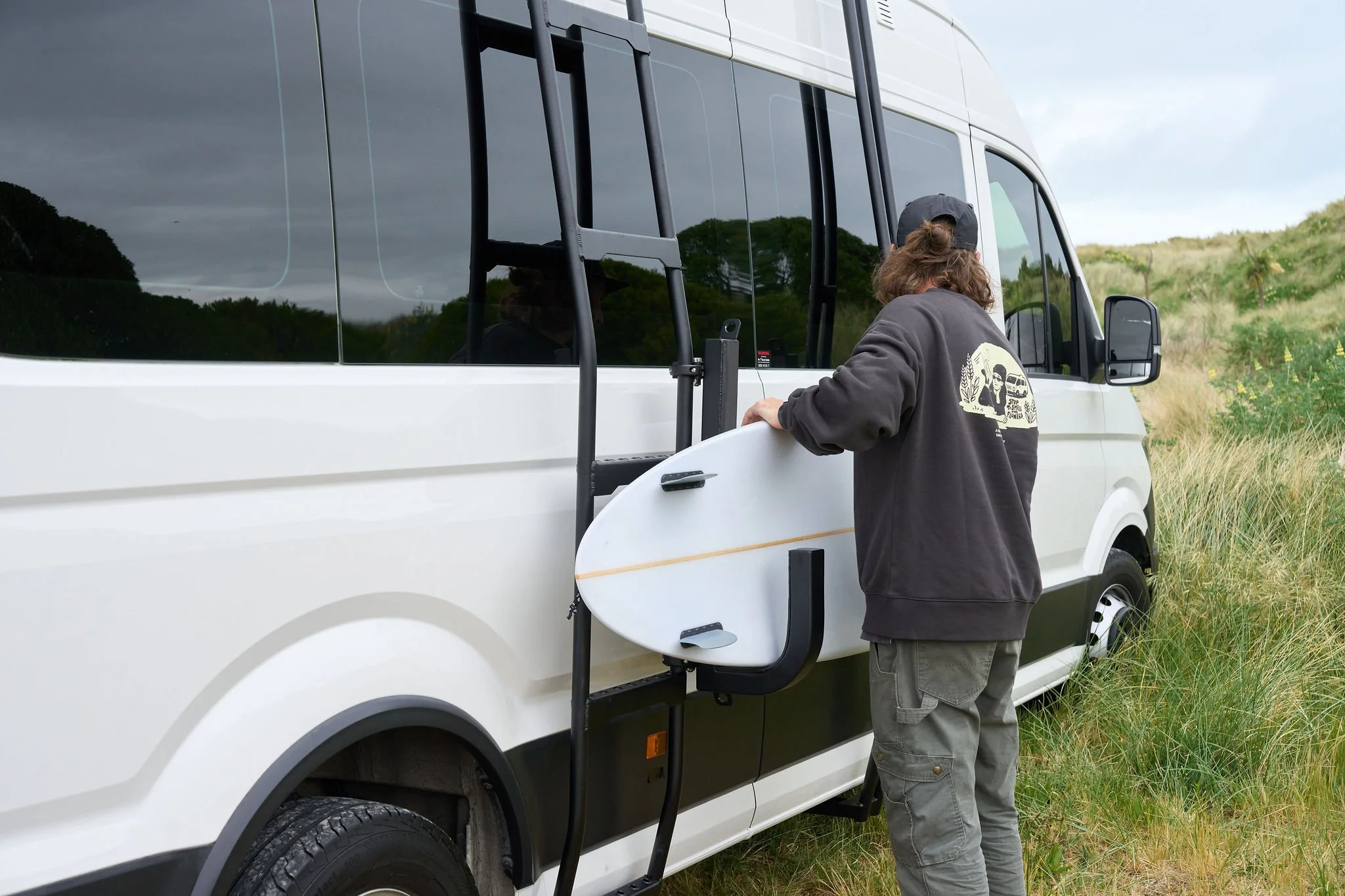 dan-loading-surfboard-exterior-matt-and-dans-campervans.jpg