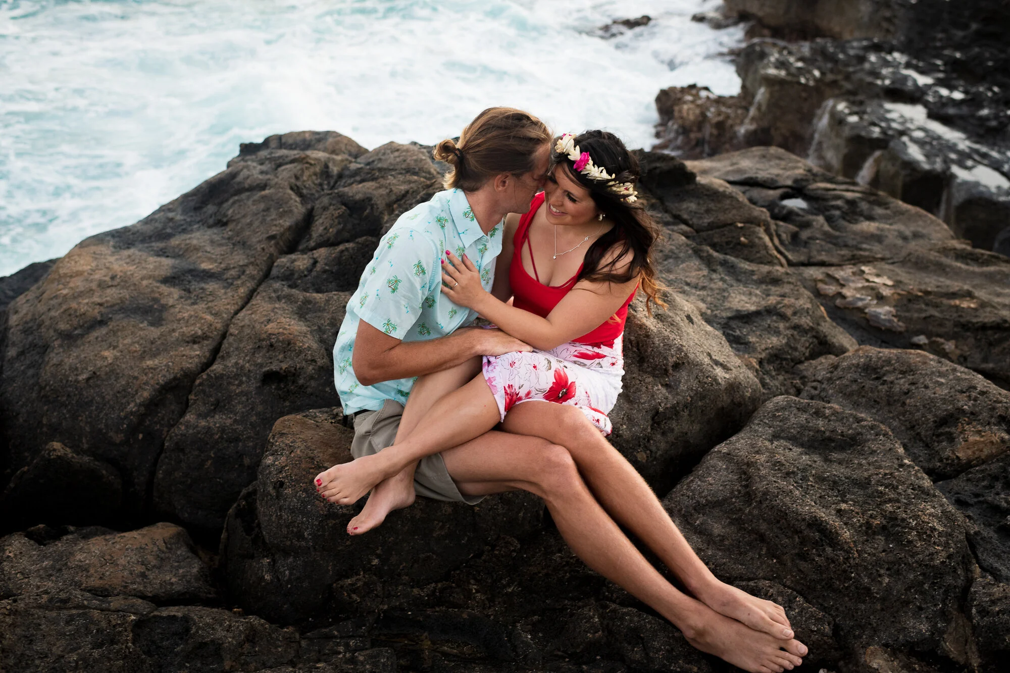 engaged couple snuggling on the rocks