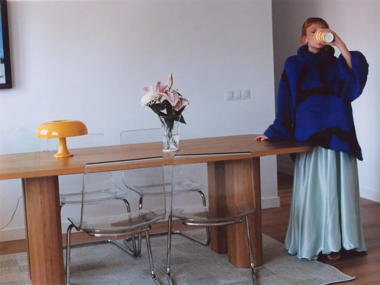Catalina standing near a table drinking a coffee