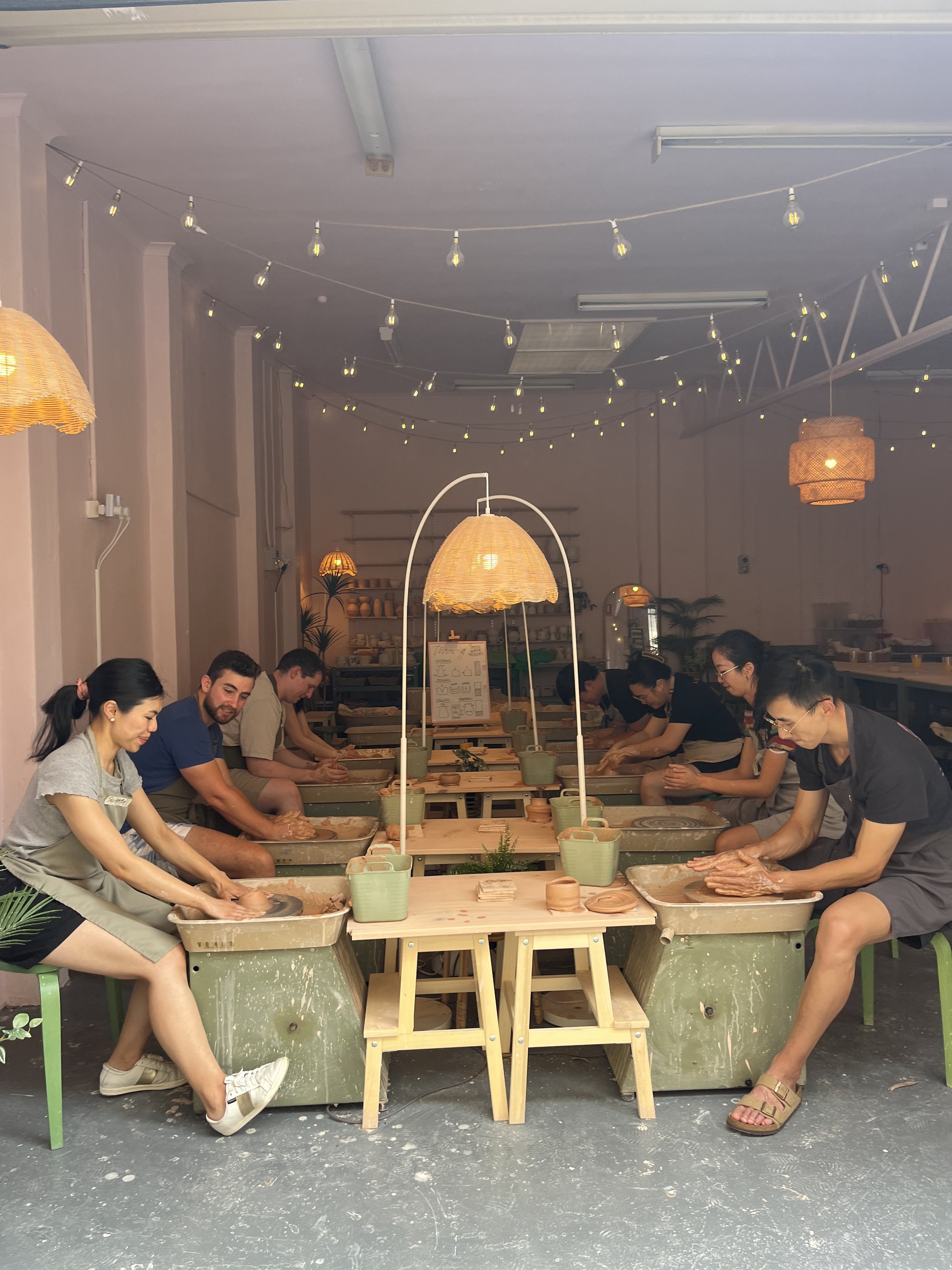 Group pottery class with participants using pottery wheels