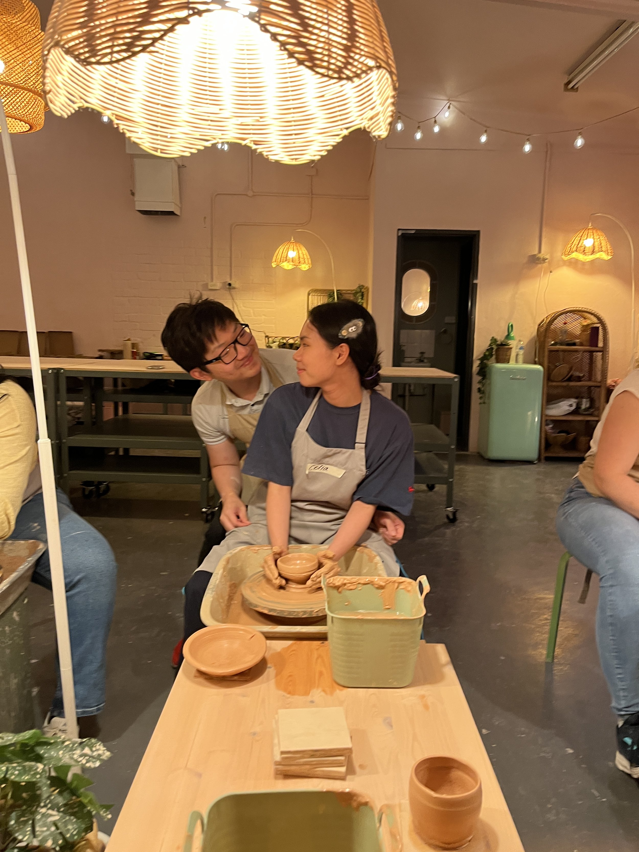 Two people working together on a pottery wheel
