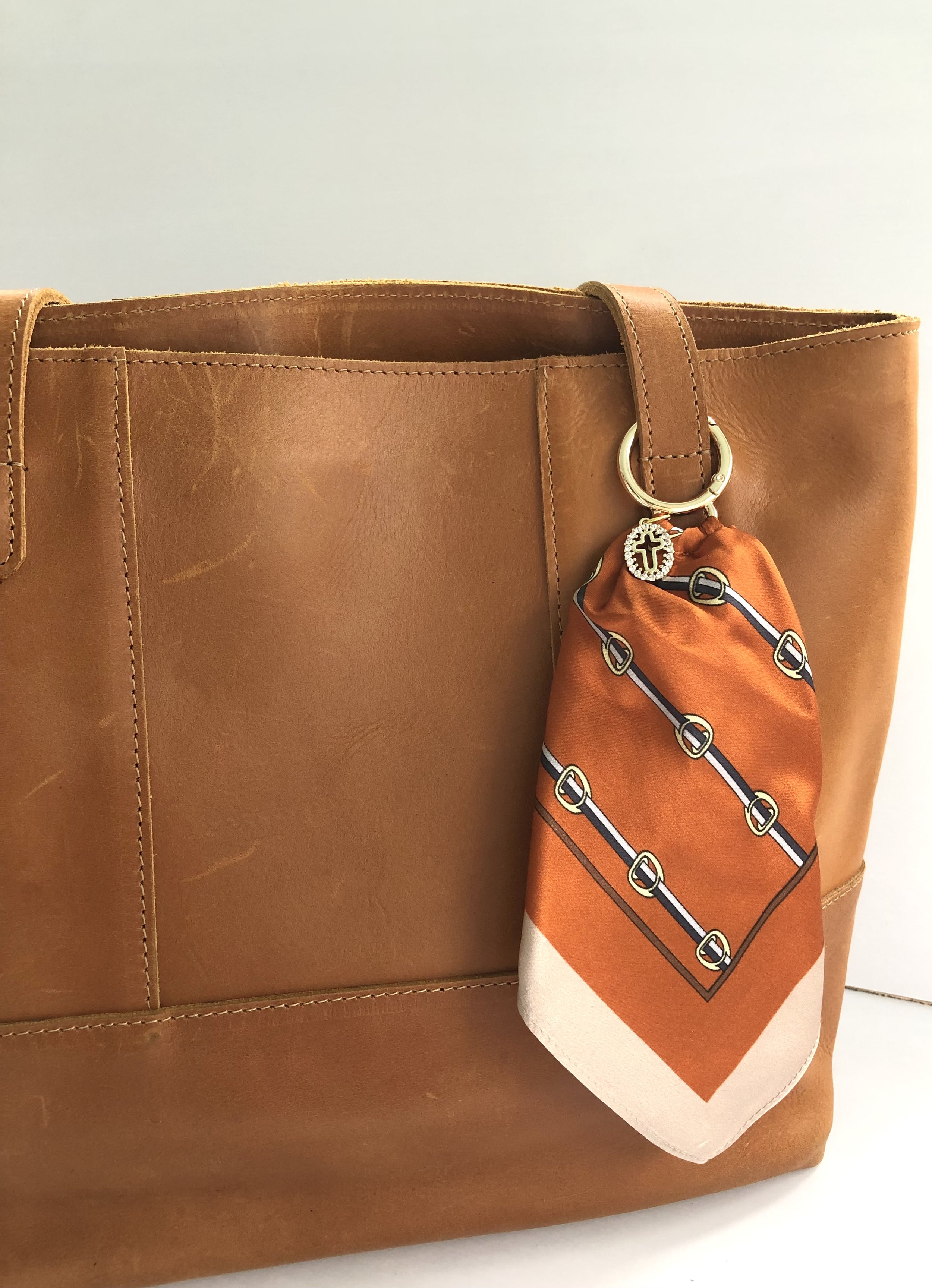 Orange_Buckle_OvalCrossCharm_OnBag_PH1_.jpeg