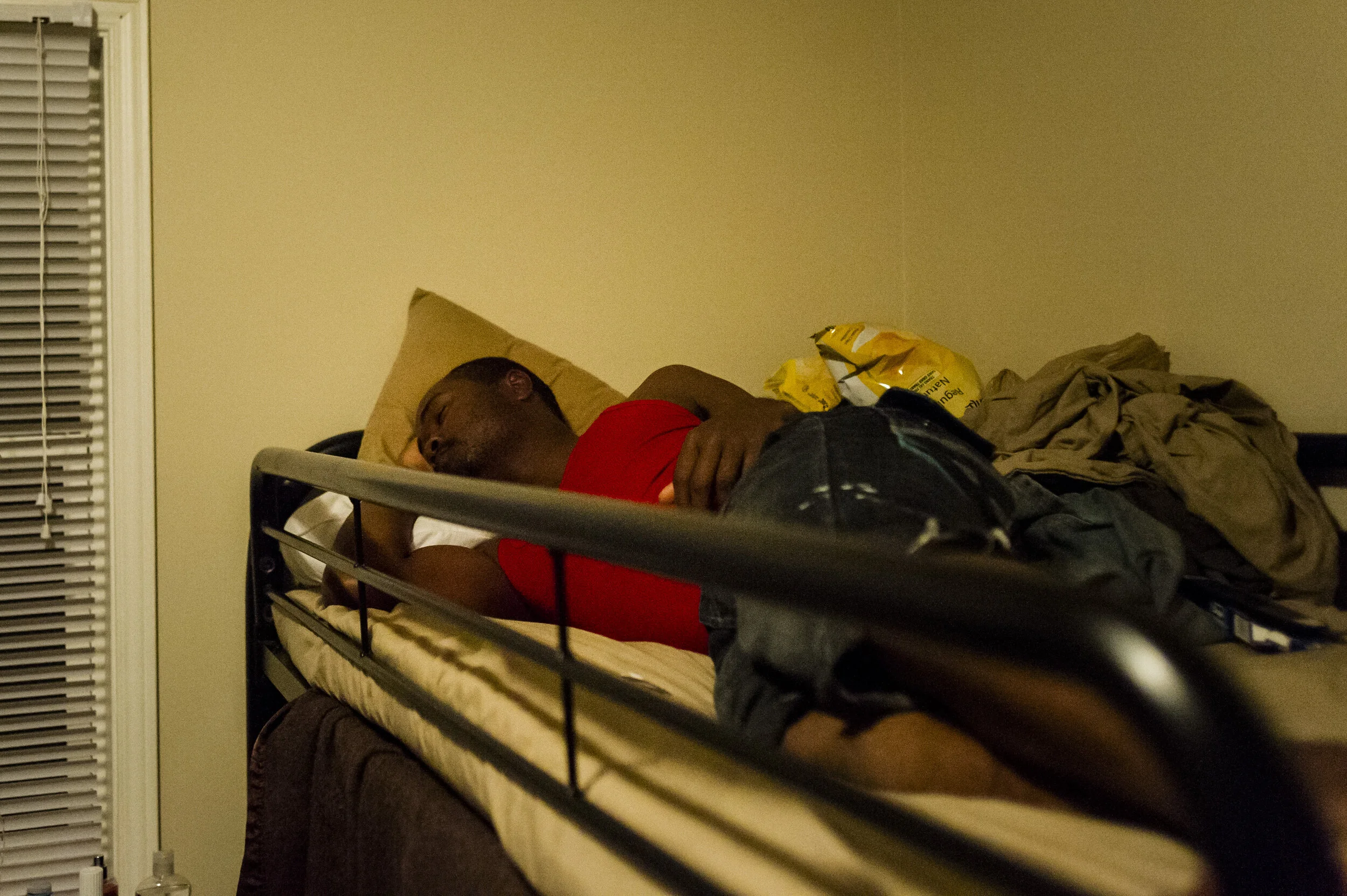 A worker sleeps in a bunk bed along with 4 others within their accommodation provided by their employer, in Clarington, Ontario, on June 6, 2015. 