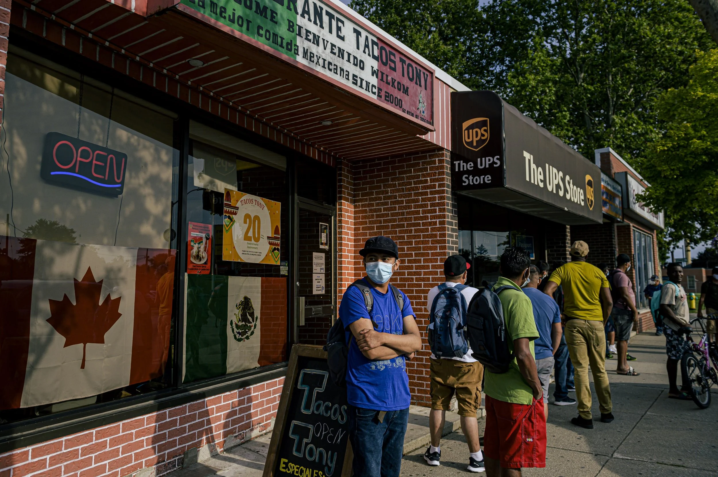  People are seen in Leamington., Ont., on Friday, July 30, 2021. Downtown Leamington has many business that cater specifically to the migrant community. After work on pay days, migrant workers often line up at these establishments to remit money back
