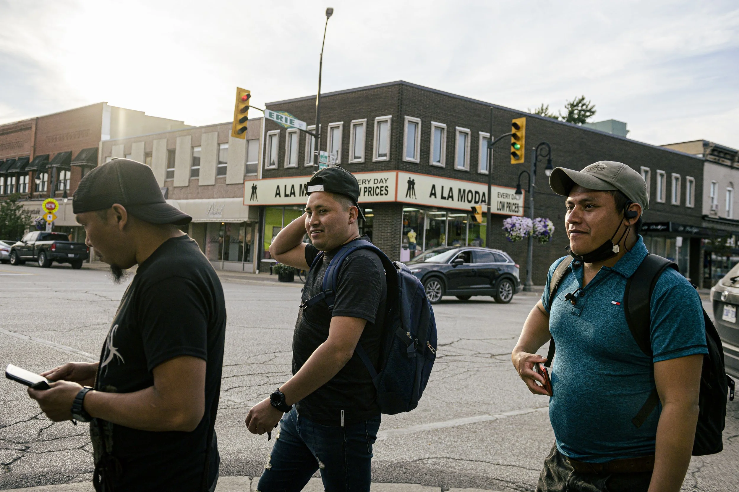  People are seen in Leamington., Ont., on Friday, July 30, 2021. Downtown Leamington has many business that cater specifically to the migrant community. After work on pay days, migrant workers often line up at these establishments to remit money back
