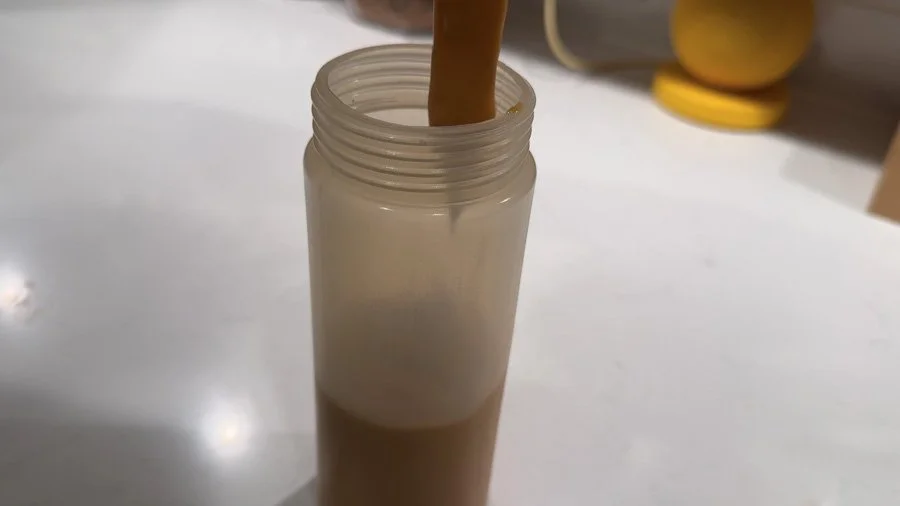 pouring spicy umami sauce into squeeze bottle