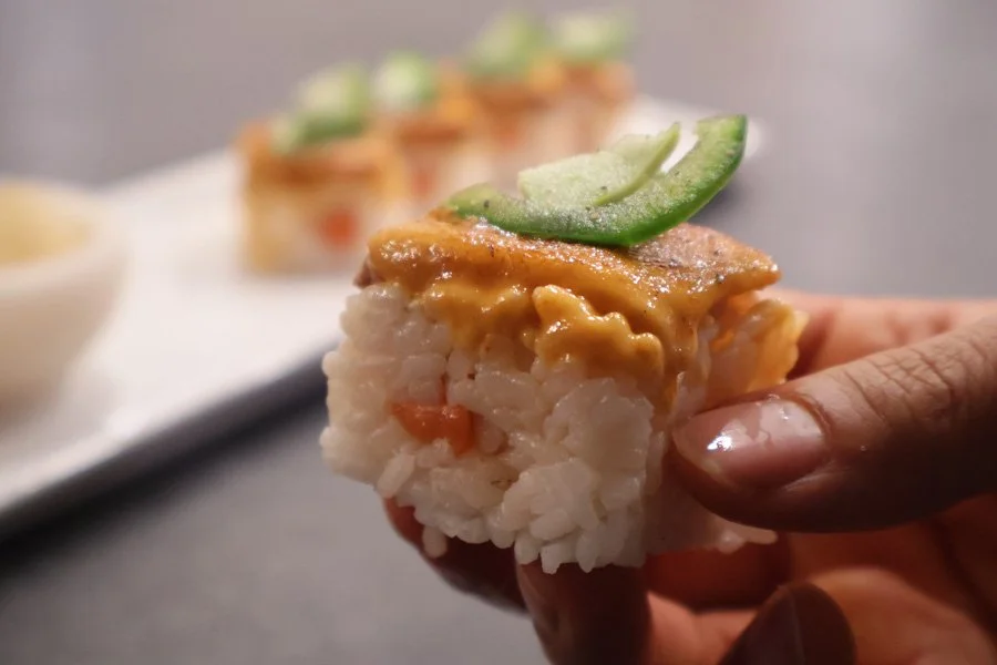 holding a piece of oshizushi