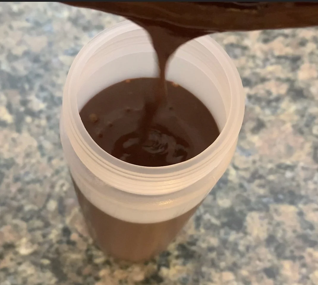 pouring mocha syrup into a squeeze bottle