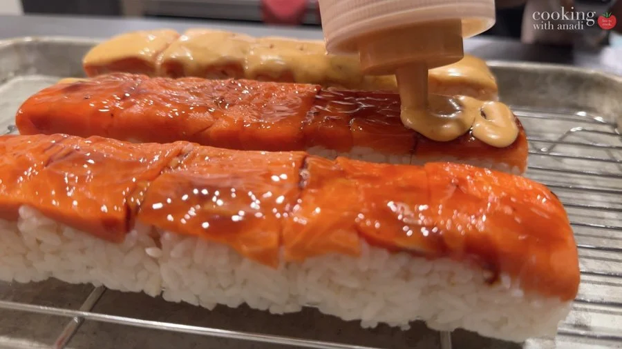 adding spicy umami on top of sushi roll