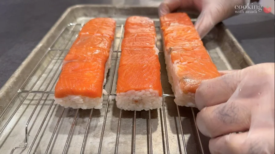 placing sushi rolls on baking sheet