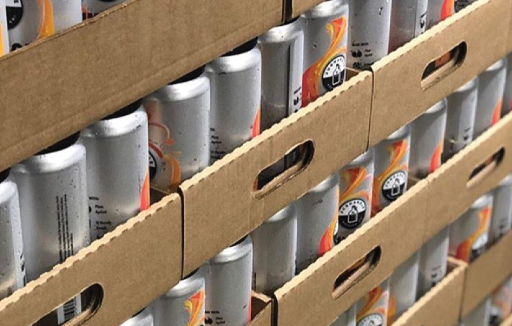 Stacks of Jug of Juice labeled aluminum cans in cardboard trays ready for distribution