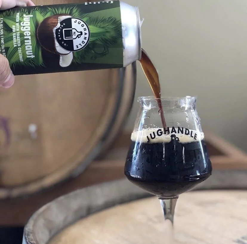 Juggernaut porter poured into a branded glass from its green illustrated can