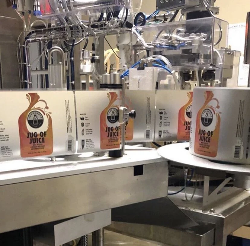 Jug of Juice printed labels running through a packaging production machine