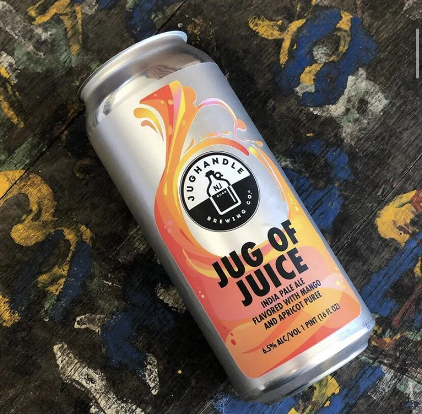 Jug of Juice can showing colorful orange and pink illustration on a textured tabletop