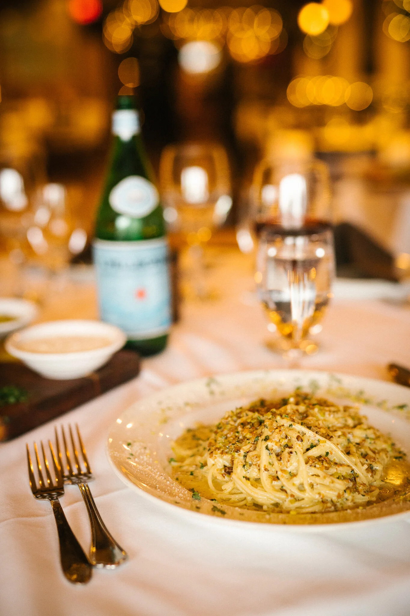 Plate of spaghetti in a warm candlelit dining setting