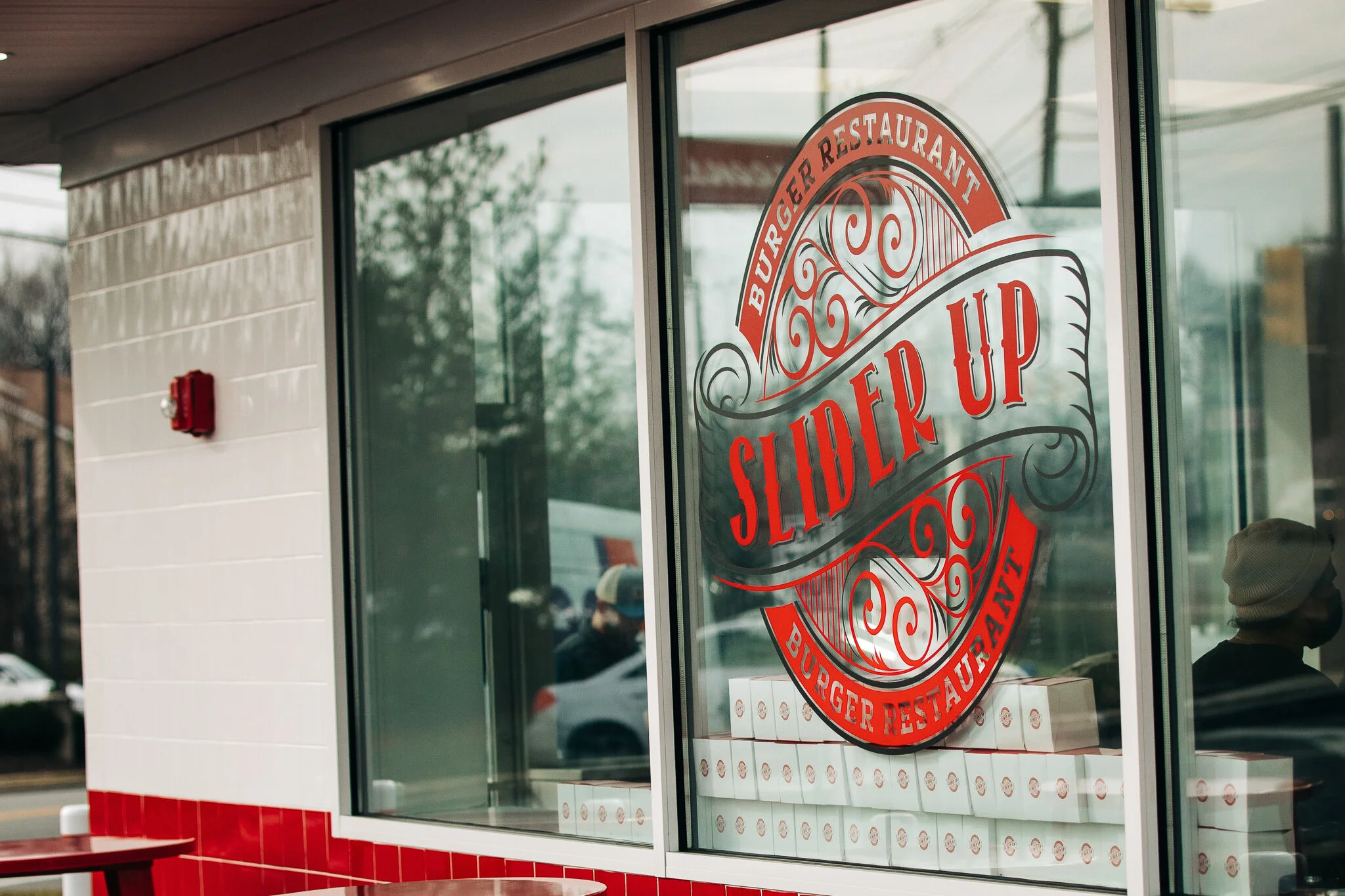 Large Slider Up circular red and white graphic on the front window of the restaurant
