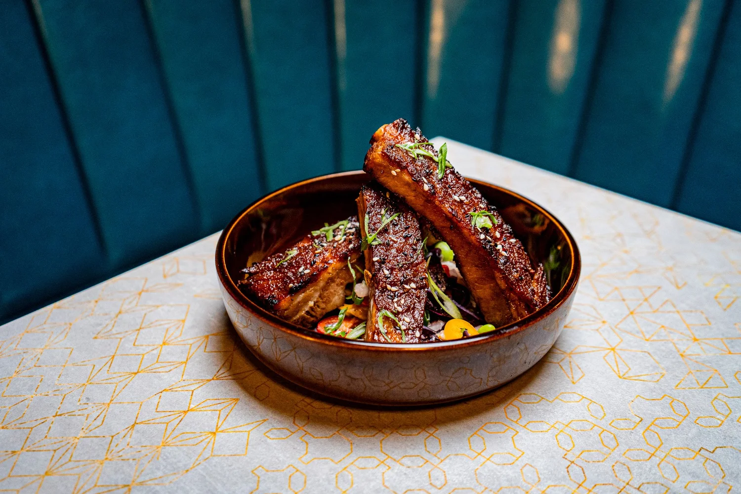 Glazed pork served in a dark ceramic bowl