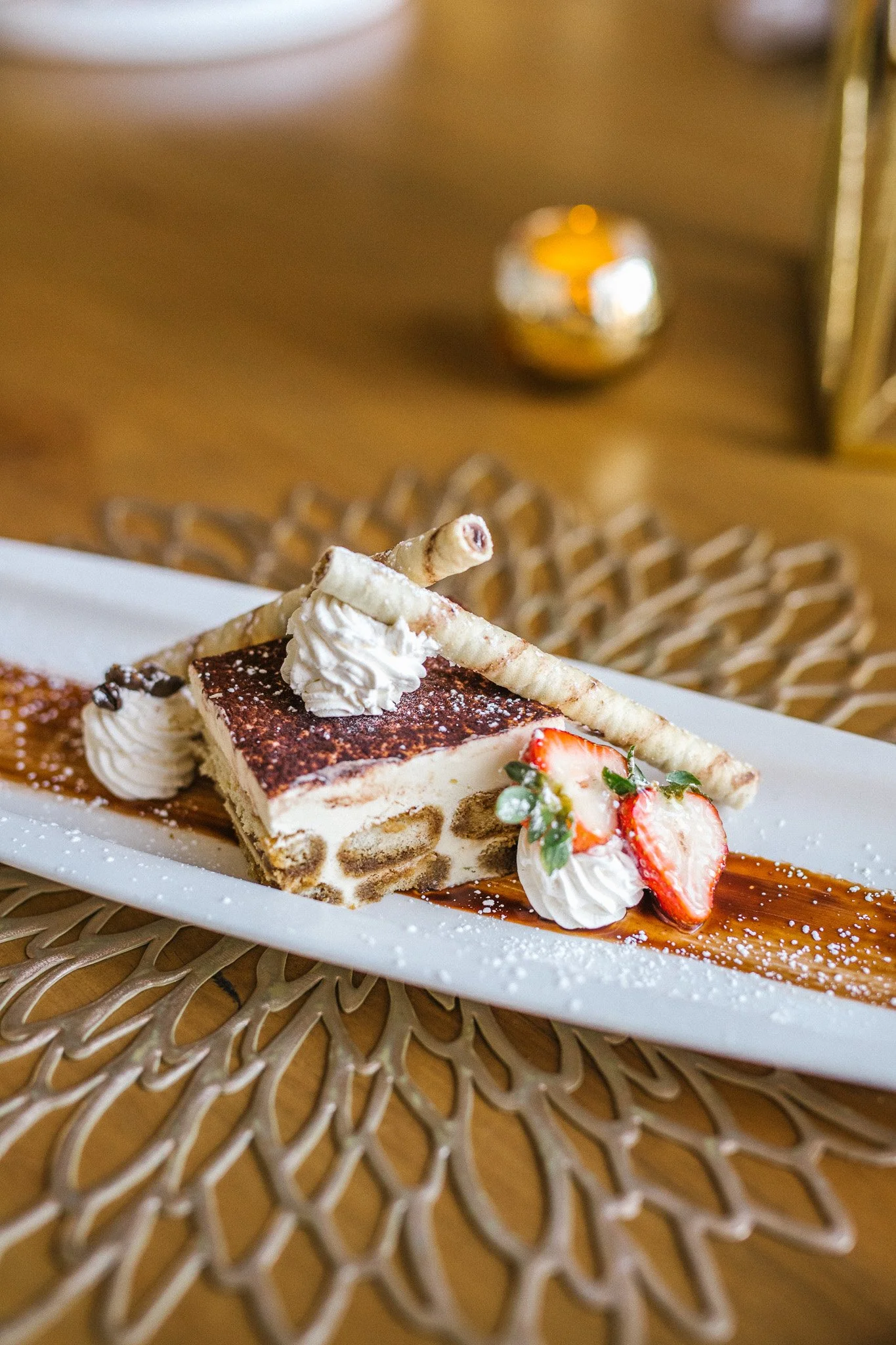 Tiramisu plated with strawberry and cream