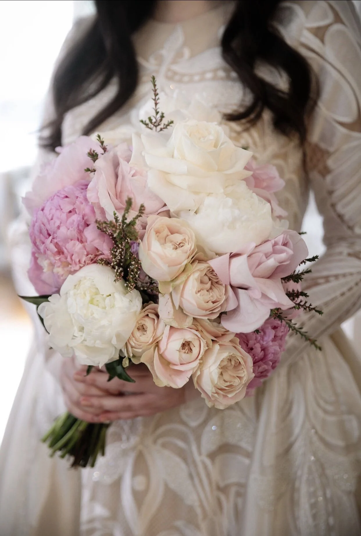 Bride holding a blush and cream Luna Moss wedding bouquet of peonies and garden roses