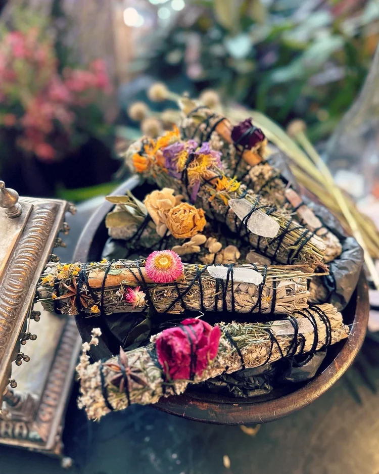 Botanical smudge sticks with dried flowers and crystals in the Luna Moss shop