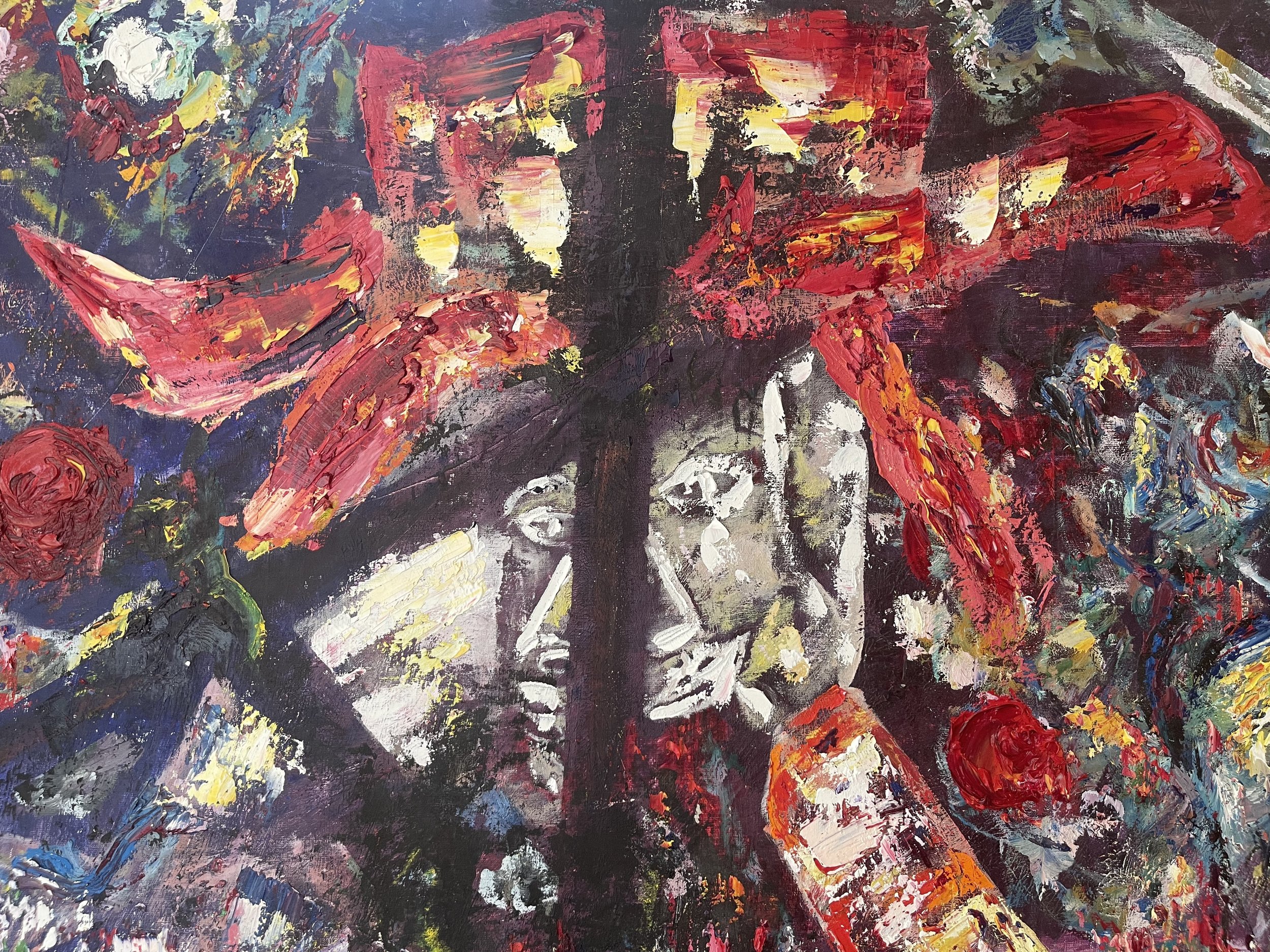 An abstract painting with bold red, yellow, black, pink, and blue brushstrokes, featuring faces of two women in black and white at the center surrounded by vibrant colors and textured patterns.