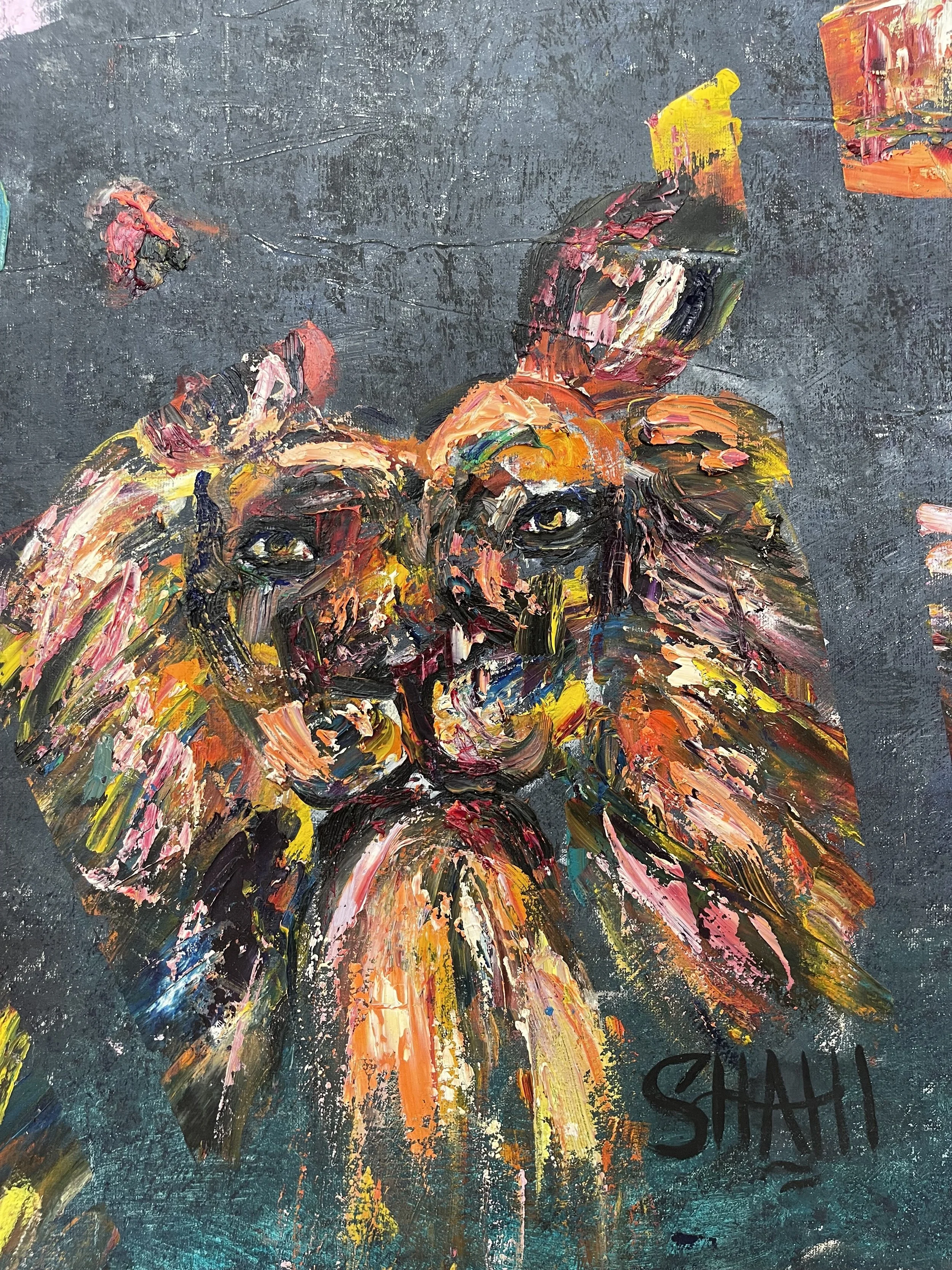 An abstract painting of a lion with vibrant, expressive brushstrokes using a variety of colors, including orange, pink, yellow, blue, and black, on a dark background. The artist's signature, 'SHAHI,' is visible in the bottom right corner.