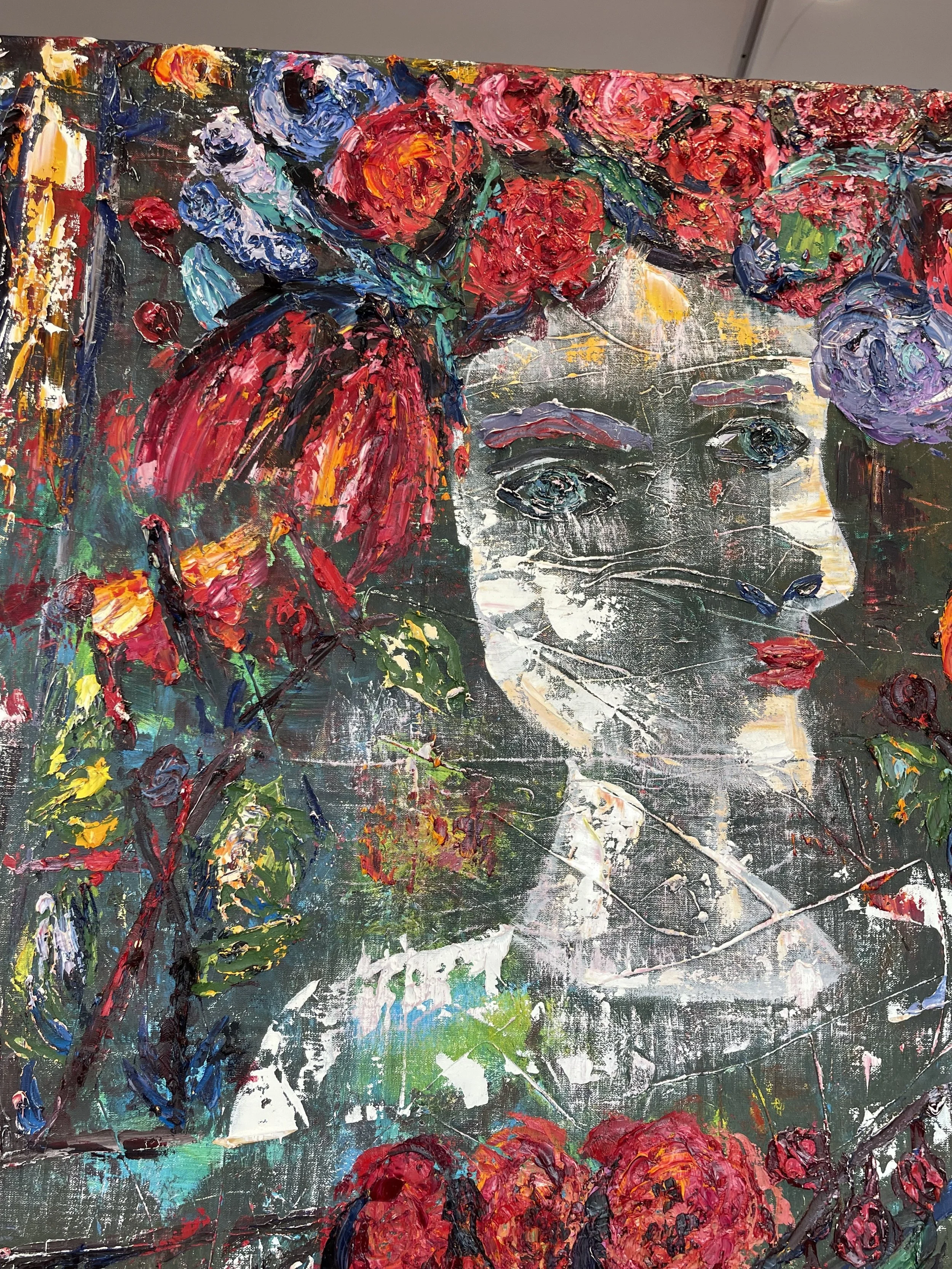 An abstract painting of a woman's face surrounded by colorful flowers and foliage, created with thick, textured brushstrokes.