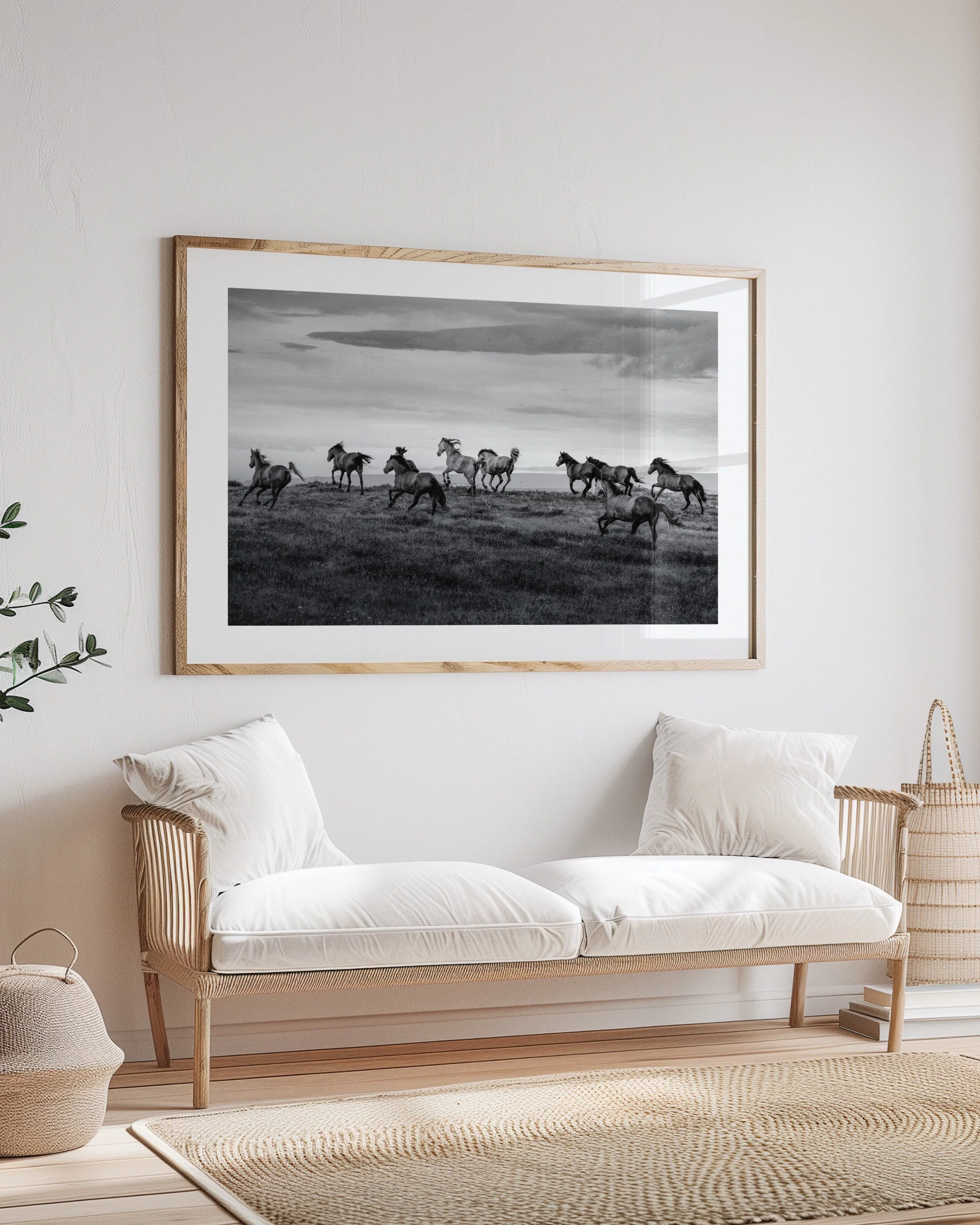 Interior room with a white sofa and a large framed black and white photograph of running horses on the wall.
