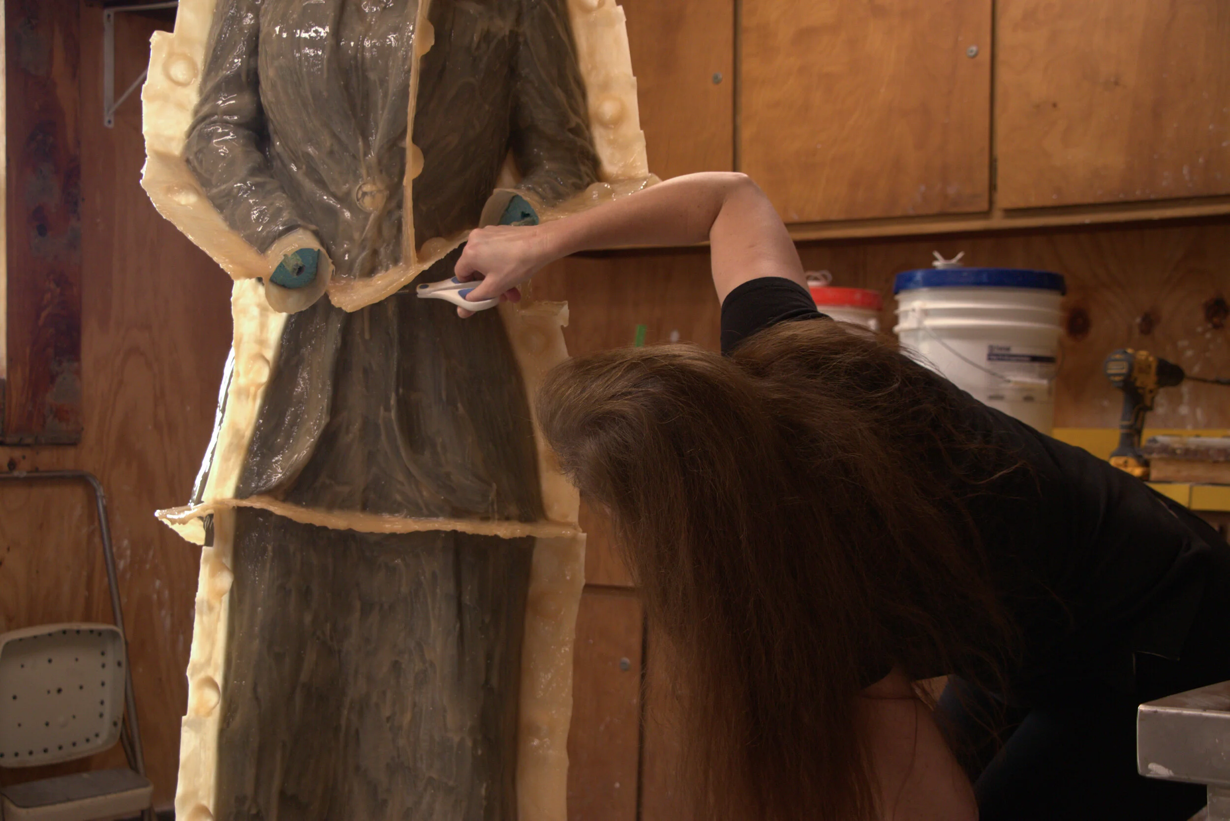 Amanda Matthews cuts away excess pieces of the rubber mold that encases the clay sculpture of Nettie Depp in her studio in Lexington, Kentucky, on March 20, 2020.