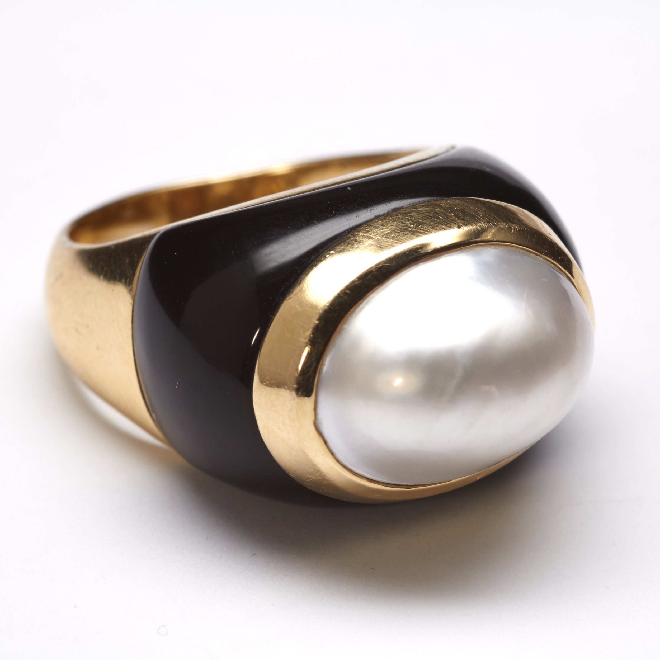 The fashion-forward designer Mazza created this onyx and mabe cultured pearl ring in 14-karat yellow gold in the 1980s. Measures 11/16" wide. Finger size 9 1/2. 