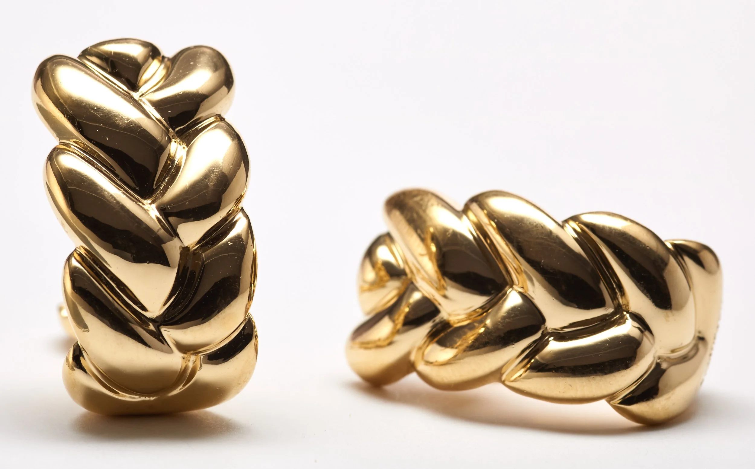 These Cartier hoop earrings have a woven wheat design. In 18-karat yellow gold, c. 1990, each prominent earring measures 1" from top to bottom X 1/2" wide.