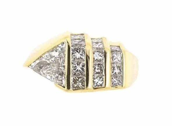In 18-karat yellow gold, a stylish "buckle"-designed ring with triangular and square brilliant cut diamonds, about 1.85 carats total. C. 1980.