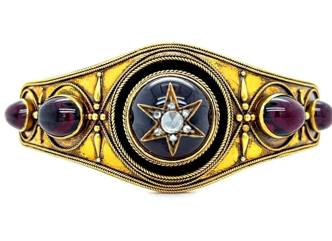 A classic mid-Victorian hinged bangle bracelet in 14-karat yellow gold, mounted with rose-cut diamondsw and garnets. 