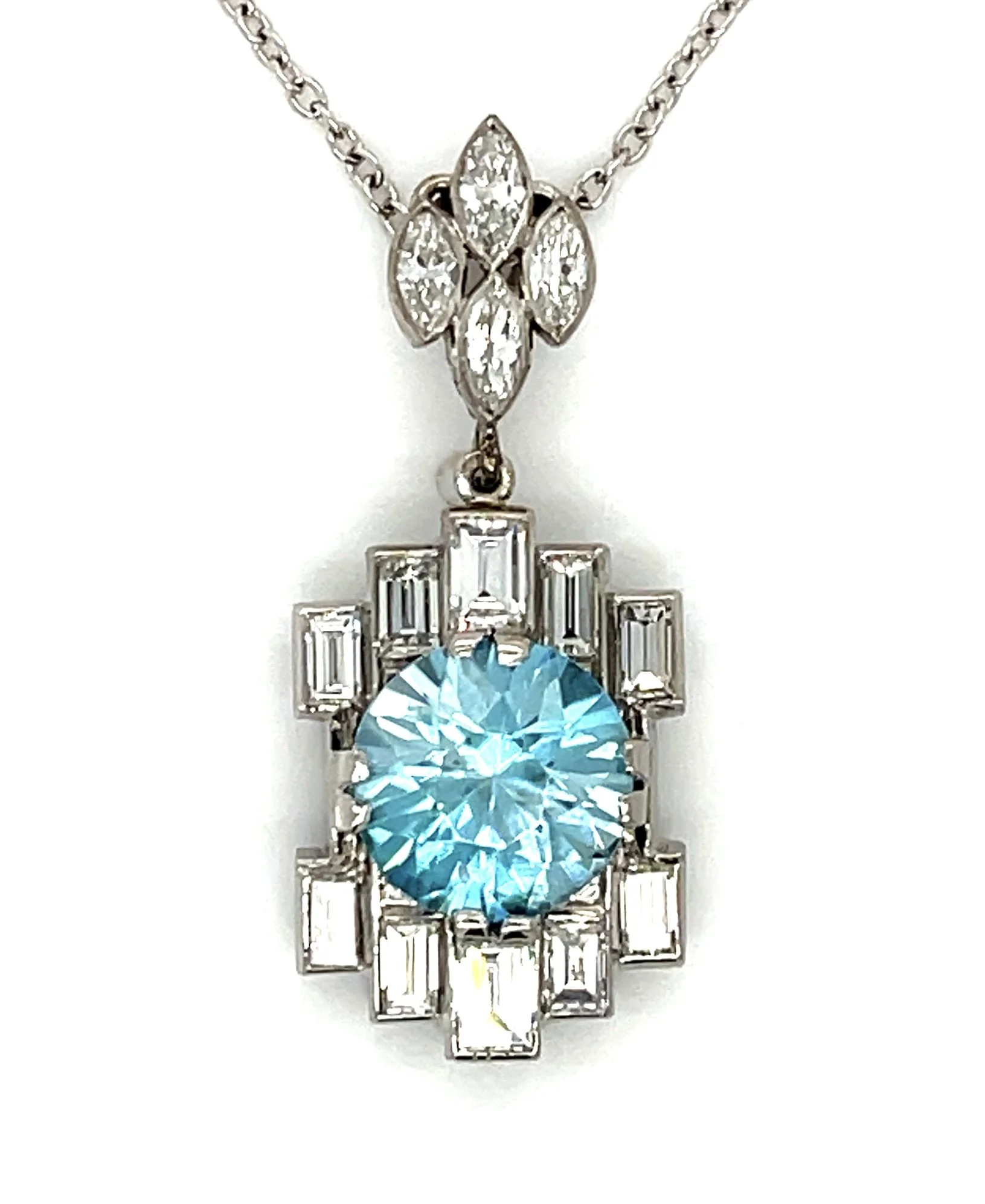 An elegant Art Deco-era pendant set with a blue zircon weighing about 4.10 carats, surroundede by marquise and baguette cut diamonds weighing about 1.56 carats total.
