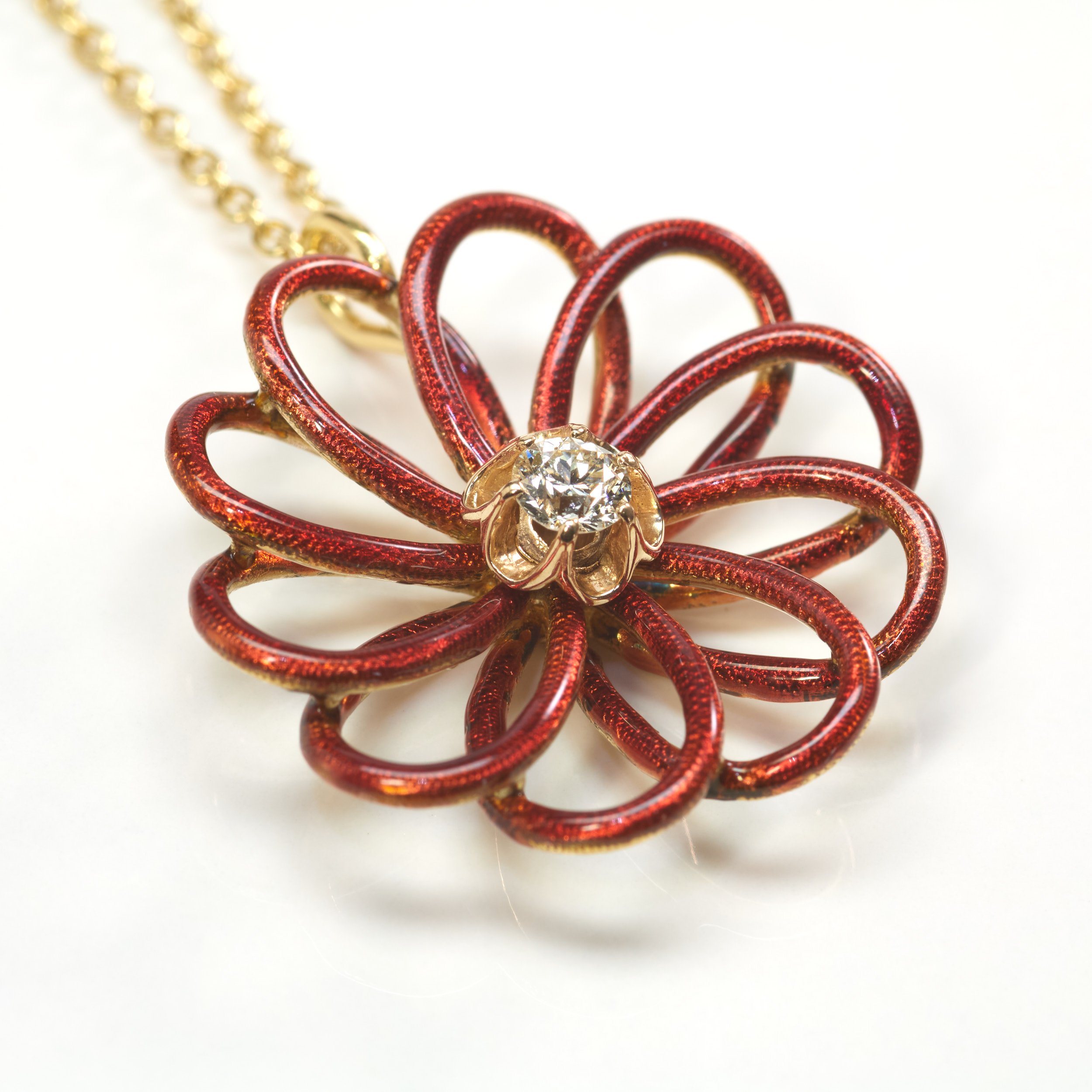 This simply striking 18-karat yellow gold pendant in red guilloché enamel dates from the Victorian pendant and is set with a round old-cut diamond weighing about 0.20 carat. Measures 1" across.