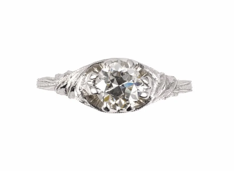 A hand-chased 18-karat white gold Art Deco engagement ring, mounted with an early American cut diamond weighing about 0.62 carats