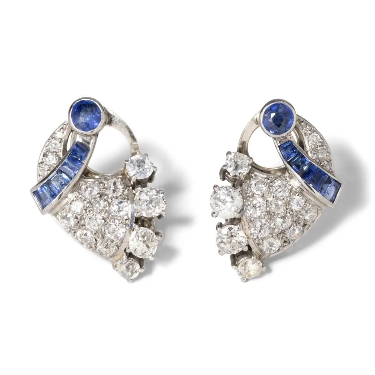 These dynamic diamond and sapphire earrings in platinum and 14k white gold unite to be worn as a brooch. Total old-mine cut diamond weight is about 3.14 carats.