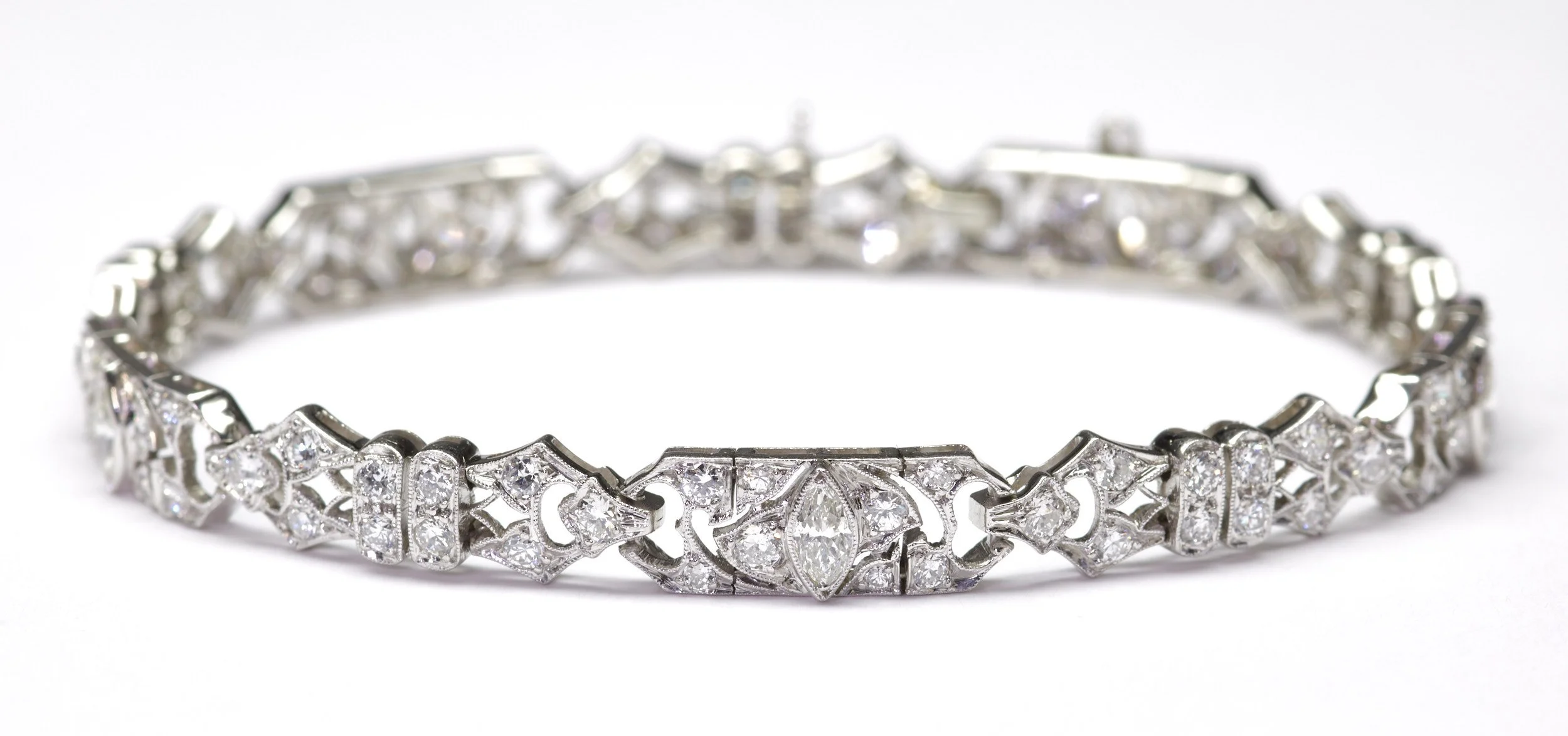In platinum, this classic Art Deco bracelet measures 1/4" wide and is mounted with 95 diamonds weighing about 2.65 carats total. Milgrain detail throughout. Measures 7" long.

