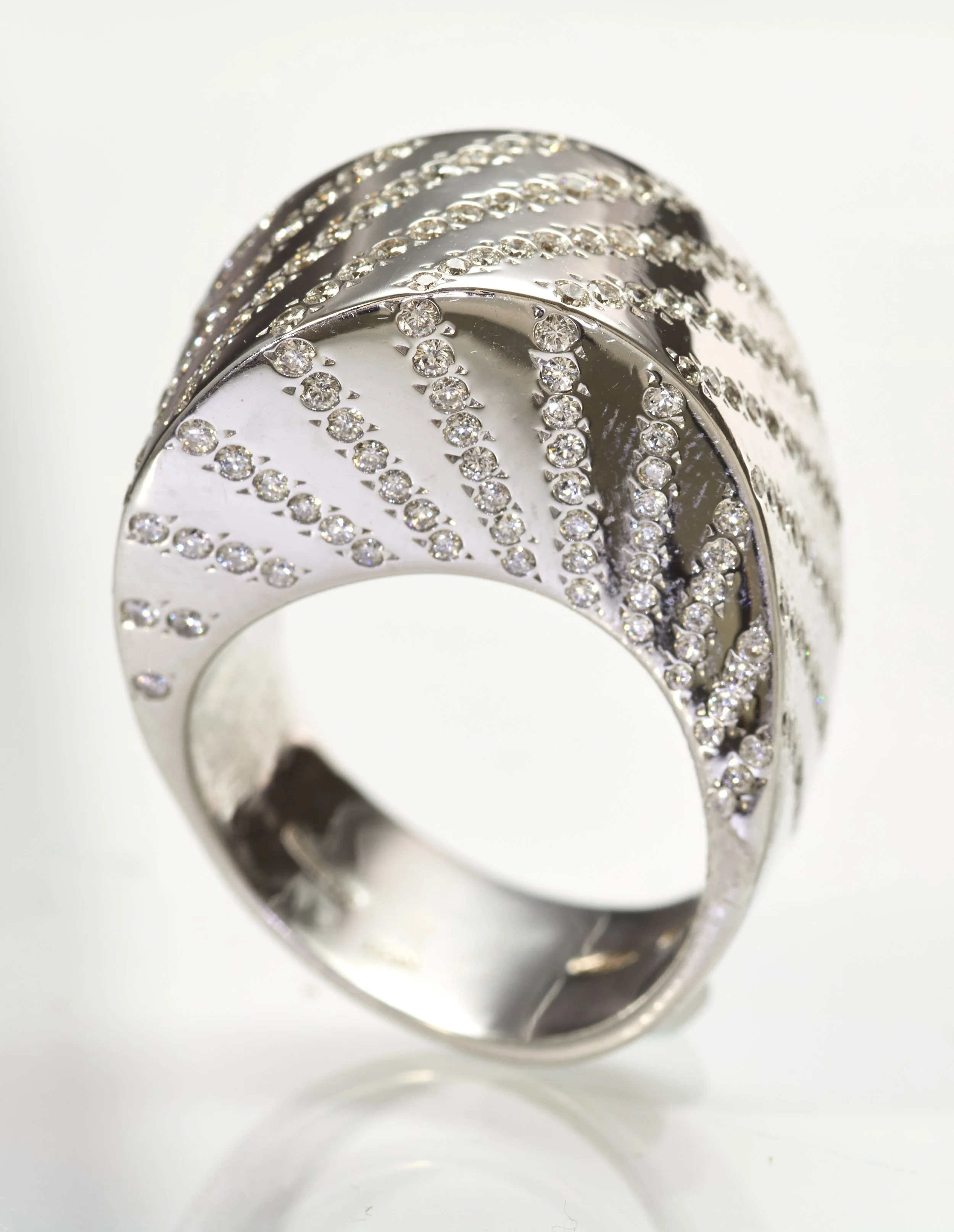By famed contemporary Italian designer Vhernier, a tall 18-karat white gold ring set with diagonal waves of 204 diamonds weighing about 1.75 carats. The dome rises 3/8" above the finger; the width at the top is 1/2".

