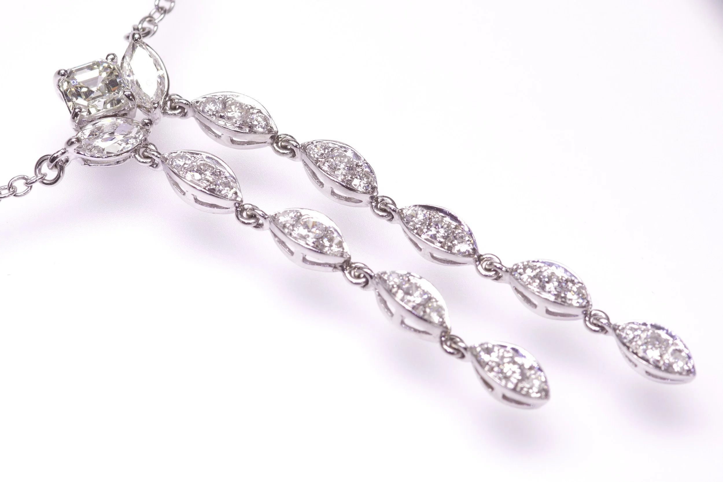 Early 1950s elegance in this platinum "negligee" pendant/necklace set with thirty square, marquise and round diamonds weighing about 1.70 carats total. The center decoration measures 2  1/8" top to bottom and the necklace has total length of 18 1/2".