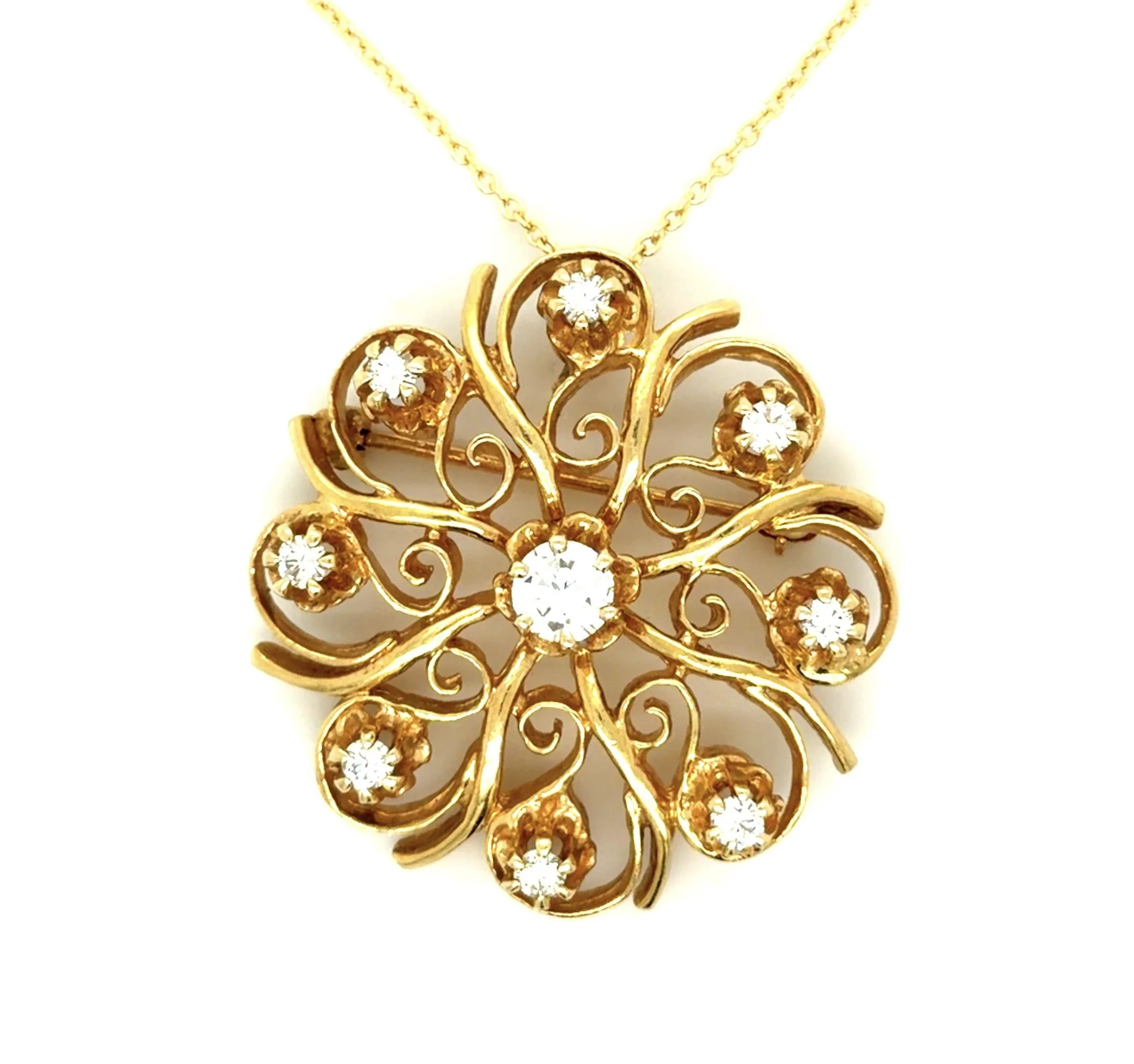 In 14-karat yellow gold, this pendant-brooch is mounted with nine fine-quality diamonds weighing about 1.10 carats total. A 1960s-era reproduction of a Victorian style.