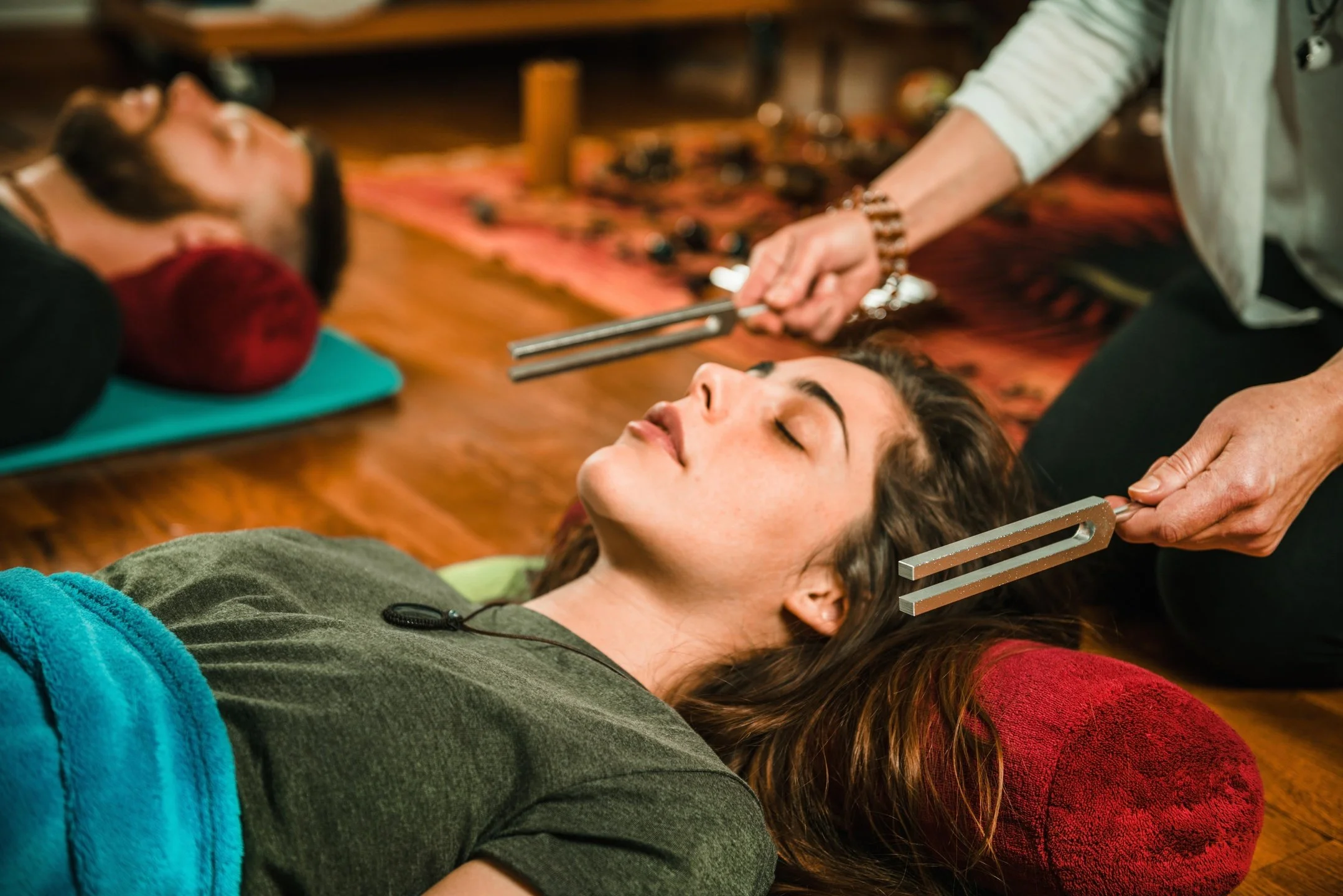 A woman receiving a sound healing with tuning forks