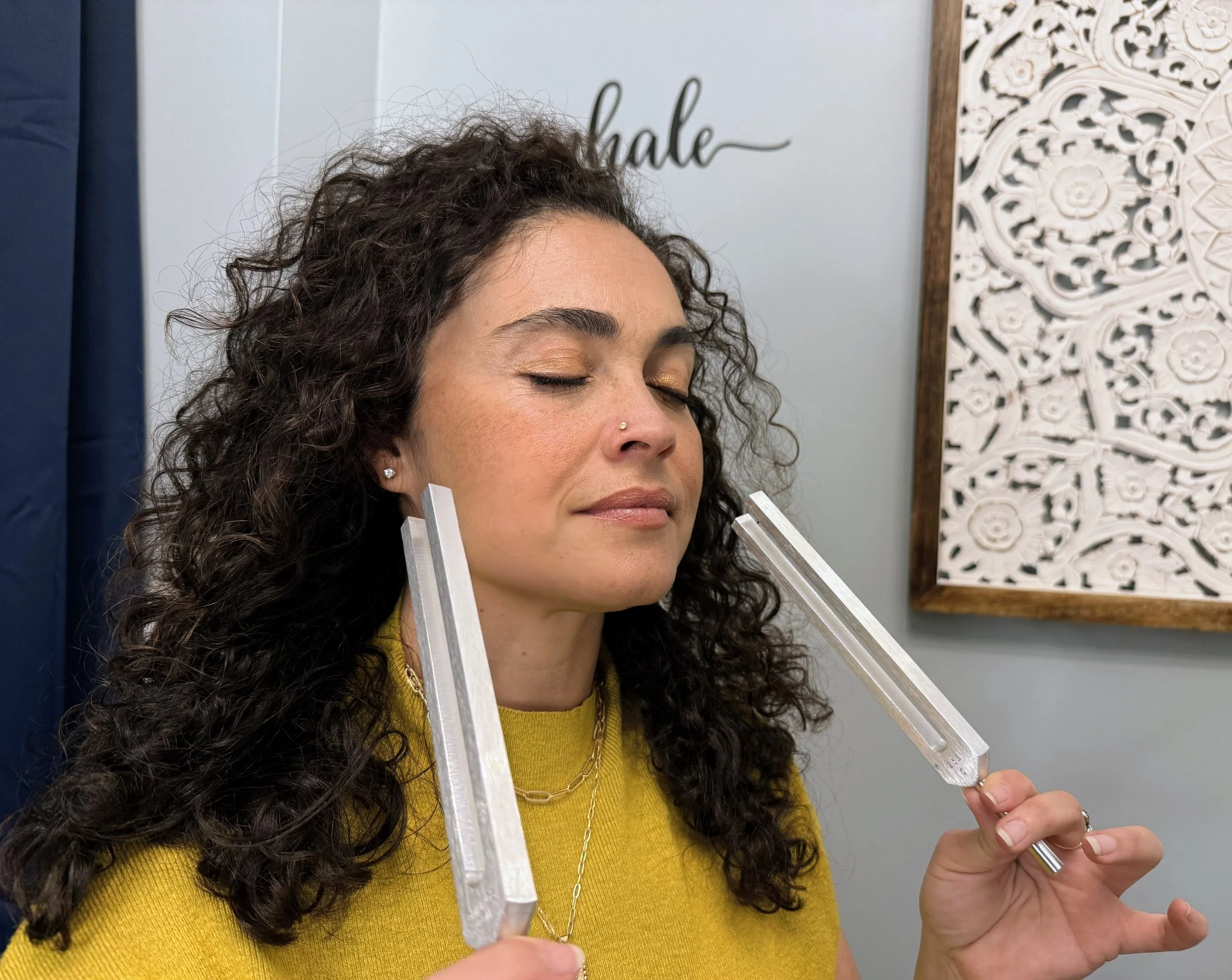 A woman receiving a sound healing with tuning forks